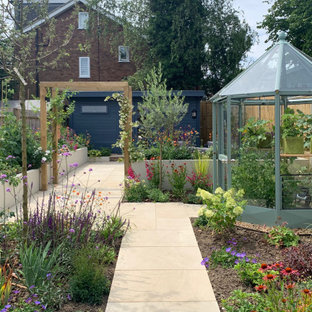 This is an example of a contemporary back full sun garden for summer in Hertfordshire with a vegetable patch.