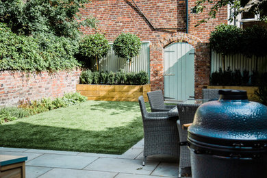 Small contemporary courtyard partial sun garden for summer in Cheshire with a raised bed.