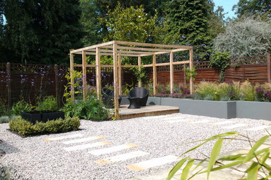 Inspiration for a medium sized contemporary back partial sun garden in Buckinghamshire with gravel.
