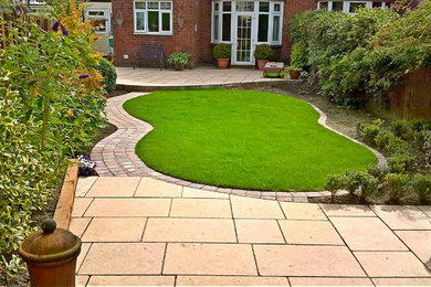 This is an example of a medium sized contemporary back garden in Other with natural stone paving.