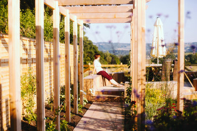 Cette photo montre un jardin arrière tendance de taille moyenne avec une exposition partiellement ombragée et une terrasse en bois.