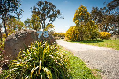 This is an example of an expansive rural sloped xeriscape full sun garden in Sydney.