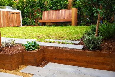 На фото: маленький солнечный, летний регулярный сад на заднем дворе в современном стиле с хорошей освещенностью, покрытием из каменной брусчатки и перегородкой для приватности для на участке и в саду с
