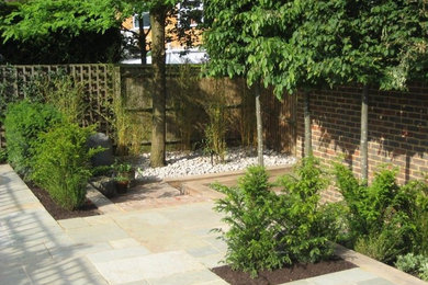 Photo of a medium sized contemporary courtyard partial sun garden for summer in Buckinghamshire with natural stone paving.