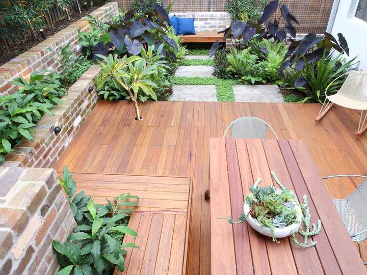 A summertime photo of a modest, tropical patio with decking and full sun.
