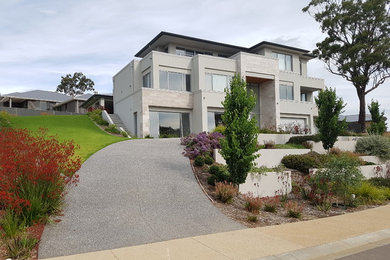 Photo of a large modern front driveway full sun garden for summer in Adelaide with a garden path.