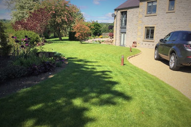 На фото: большой солнечный, летний участок и сад на переднем дворе в стиле кантри с хорошей освещенностью и покрытием из каменной брусчатки