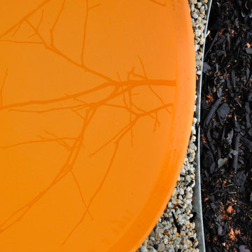 Detail of persimmon birdbath with steel garden edge and purple ajuga