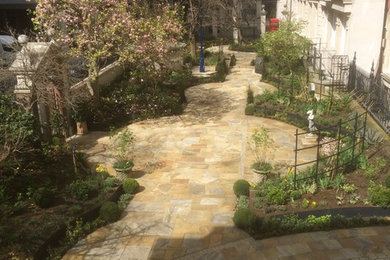 Design ideas for a large classic back formal partial sun garden in London with natural stone paving.