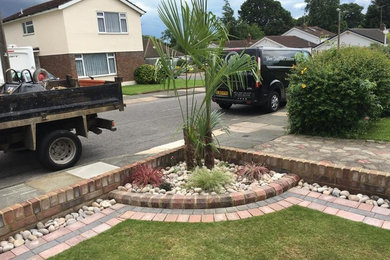 Inspiration for a large modern front driveway full sun garden for summer in Essex with a garden path and brick paving.