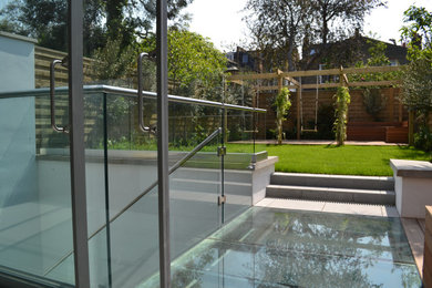 Geometrische, Mittelgroße Moderne Pflanzenwand im Frühling, hinter dem Haus mit direkter Sonneneinstrahlung und Natursteinplatten in London