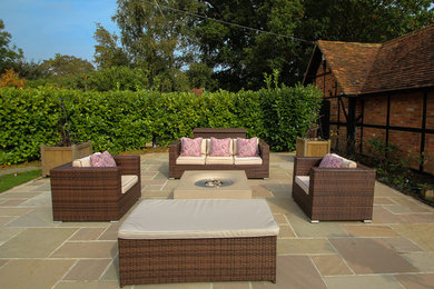 Photo of a medium sized classic back patio in Berkshire with natural stone paving.