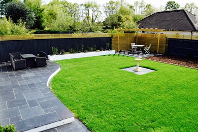 Inspiration for a contemporary garden in Surrey with natural stone paving.