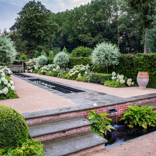 This is an example of a large traditional garden in Essex with a water feature.