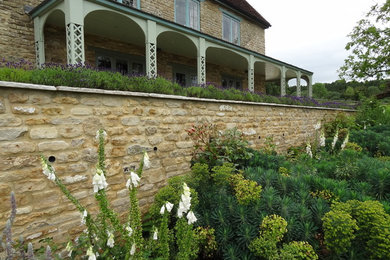 Design ideas for a large rural front garden in Other with natural stone paving.
