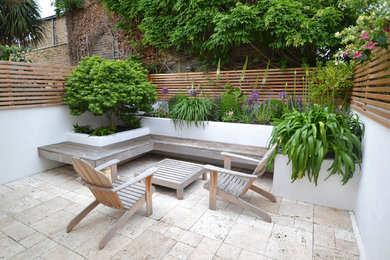 Kleiner Moderner Garten im Sommer, hinter dem Haus mit direkter Sonneneinstrahlung, Natursteinplatten und Kübelpflanzen in London