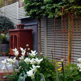 Geometrische, Kleine, Halbschattige Stilmix Gartenkamin im Sommer, hinter dem Haus mit Natursteinplatten in Kent