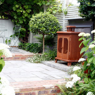 Geometrische, Kleine, Halbschattige Stilmix Gartenkamin im Sommer, hinter dem Haus mit Natursteinplatten in Kent