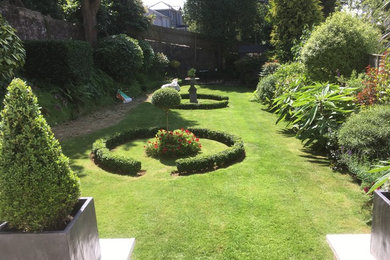 Photo of a medium sized world-inspired back formal partial sun garden in Devon.