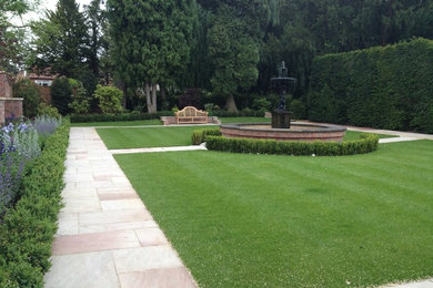 Medium sized classic formal partial sun garden for summer in Other with natural stone paving.