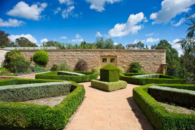 Réalisation d'un grand jardin à la française arrière tradition avec une exposition ensoleillée et des pavés en béton.