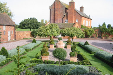 Design ideas for a classic side formal full sun garden in West Midlands with gravel.