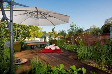Small modern courtyard formal partial sun garden for summer in Canberra - Queanbeyan with a vegetable patch and decking.