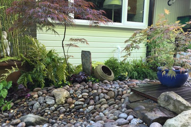 Small contemporary front partial sun garden for autumn in London with gravel.