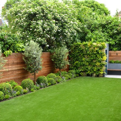 Design ideas for a mid-sized contemporary full sun backyard stone landscaping in London.