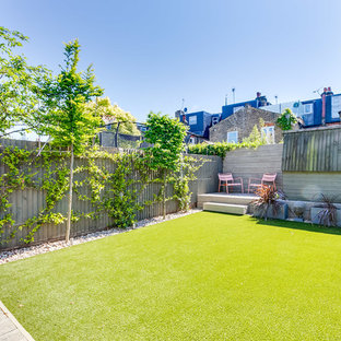 Ejemplo de jardín actual, en patio trasero, con jardín vertical, exposición parcial al sol y entablado