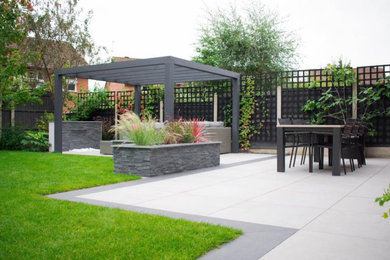 Medium sized contemporary back formal garden for summer in West Midlands with a waterfall.