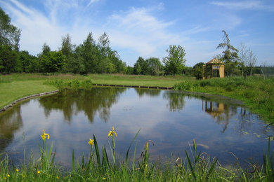 This is an example of a rural garden in Dorset with a pond.