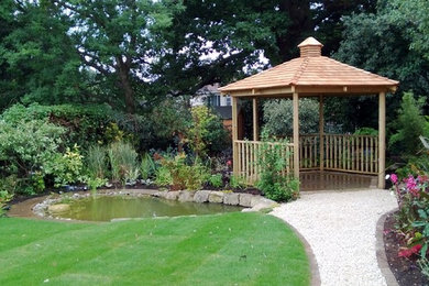 Ejemplo de jardín clásico pequeño en verano en patio trasero con jardín francés, exposición parcial al sol y adoquines de piedra natural