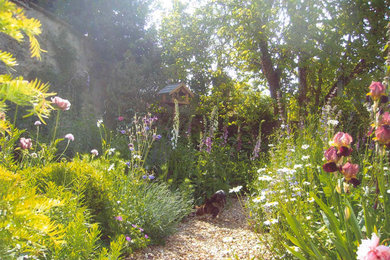 Ejemplo de jardín tradicional de tamaño medio en patio con jardín francés y exposición parcial al sol
