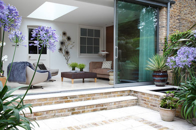 Design ideas for a small contemporary back formal garden in London with a pond and brick paving.