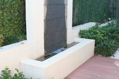 This is an example of a mid-sized contemporary partial sun side yard concrete paver formal garden in Sydney for spring.