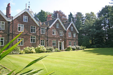 Geometrischer, Großer, Halbschattiger Klassischer Garten im Sommer, hinter dem Haus mit Natursteinplatten in Cheshire