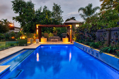 Diseño de piscina actual de tamaño medio en patio trasero