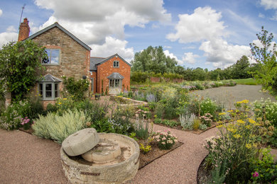 Inspiration for a large farmhouse front driveway full sun garden in West Midlands with gravel and a garden path.