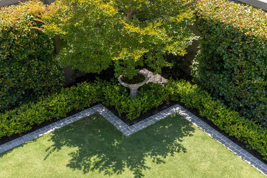 Large classic back formal full sun garden in Perth with a living wall and natural stone paving.