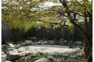 Diseño de jardín contemporáneo grande en primavera en patio trasero con fuente, exposición parcial al sol y adoquines de piedra natural
