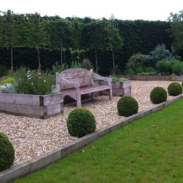 Hornbeam High panel hedging behind an oversized antique bench and large box ball