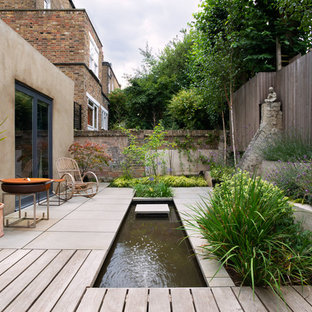 Inspiration for a small world-inspired back formal partial sun garden for summer in London with a pond and natural stone paving.