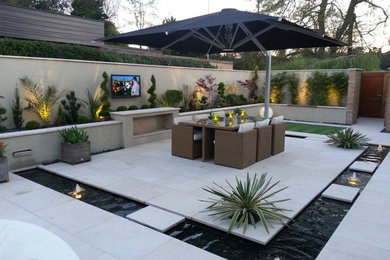 Inspiration for a medium sized contemporary courtyard patio in West Midlands with a water feature and concrete paving.
