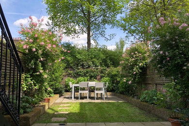 Classic back garden in London with concrete paving.