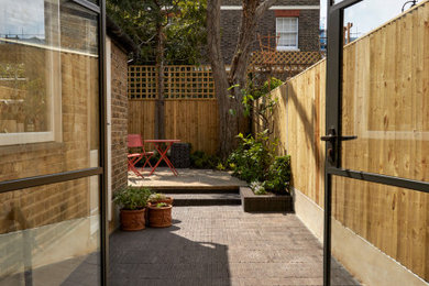 Inspiration for a small classic back garden in London with brick paving.