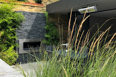 Источник вдохновения для домашнего уюта: летний регулярный сад среднего размера на заднем дворе в современном стиле с уличным камином, полуденной тенью и покрытием из каменной брусчатки