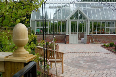 Imagen de jardín clásico de tamaño medio en patio trasero con huerto, exposición total al sol y adoquines de ladrillo