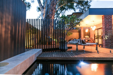 This is an example of a small modern partial sun garden for summer in Adelaide with decking.