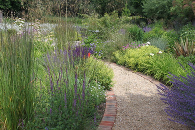 Large modern partial sun garden in Surrey with gravel.
